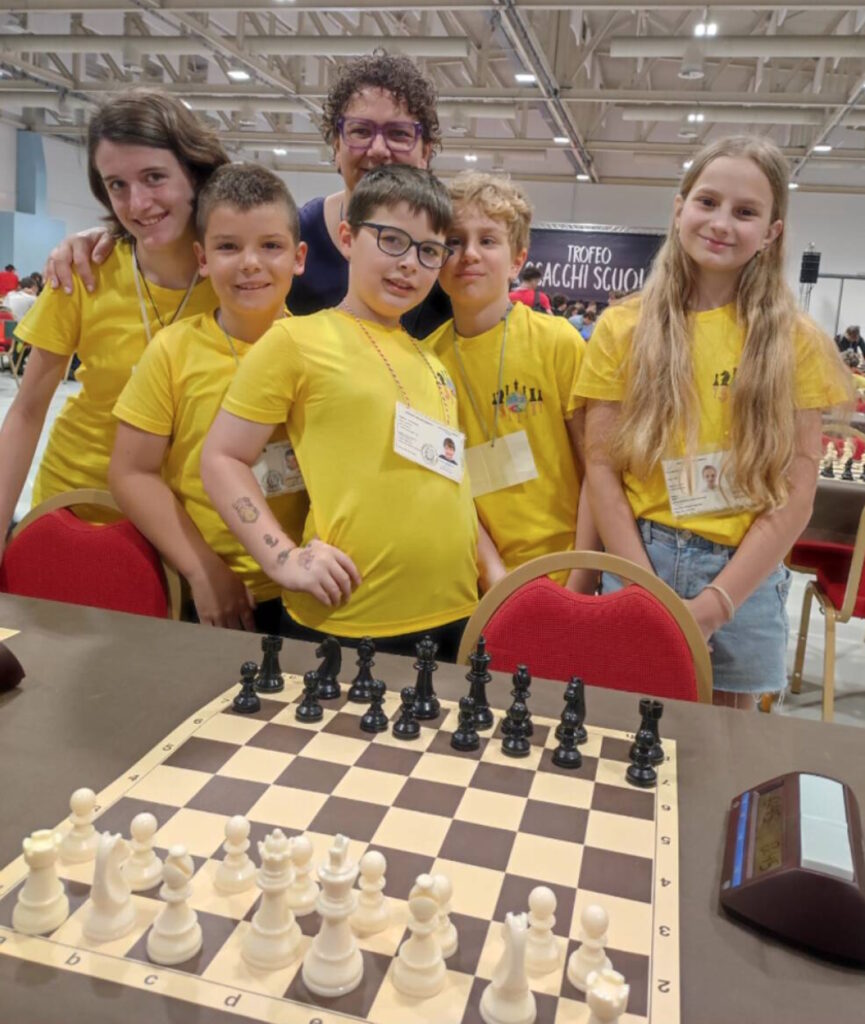 Foto di gruppo di alunne e alunni assieme a un'accompagnatrice al torneo di scacchi