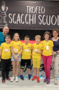 Foto di gruppo di alunne e alunni assieme a un'accompagnatrice e un accompagnatore al torneo di scacchi