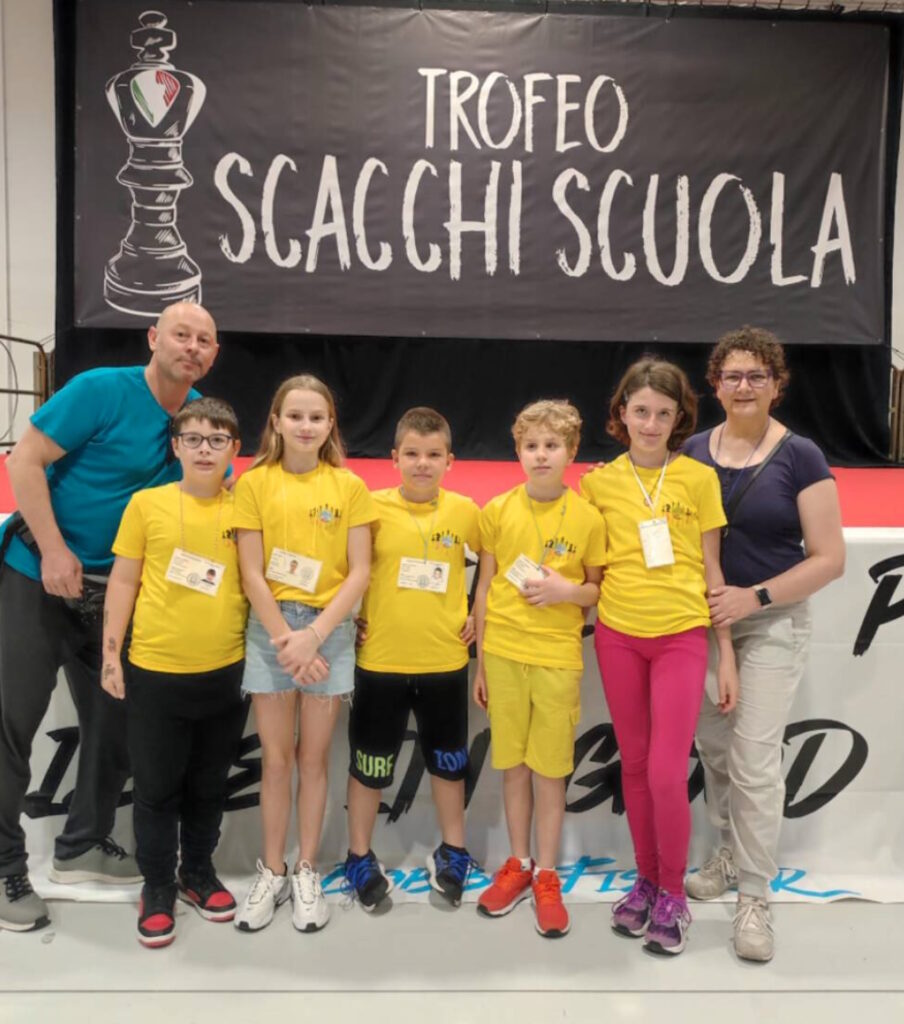 Foto di gruppo di alunne e alunni assieme a un'accompagnatrice e un accompagnatore al torneo di scacchi