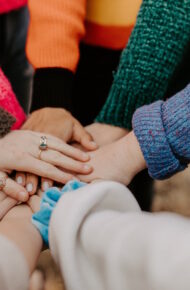 Le mani di persone diverse si stringono fra loro