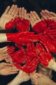 Mani dipinte che vicine formano un cuore rosso